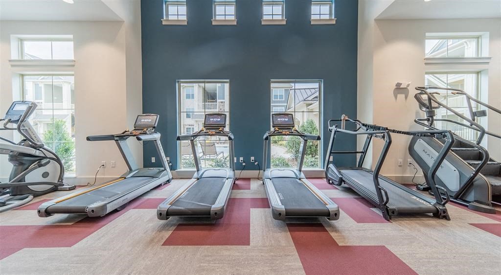 a fitness center with treadmills and elliptical machines