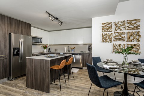 A modern kitchen with a dining table set for two.