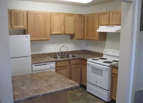 a kitchen with white appliances and wooden cabinets