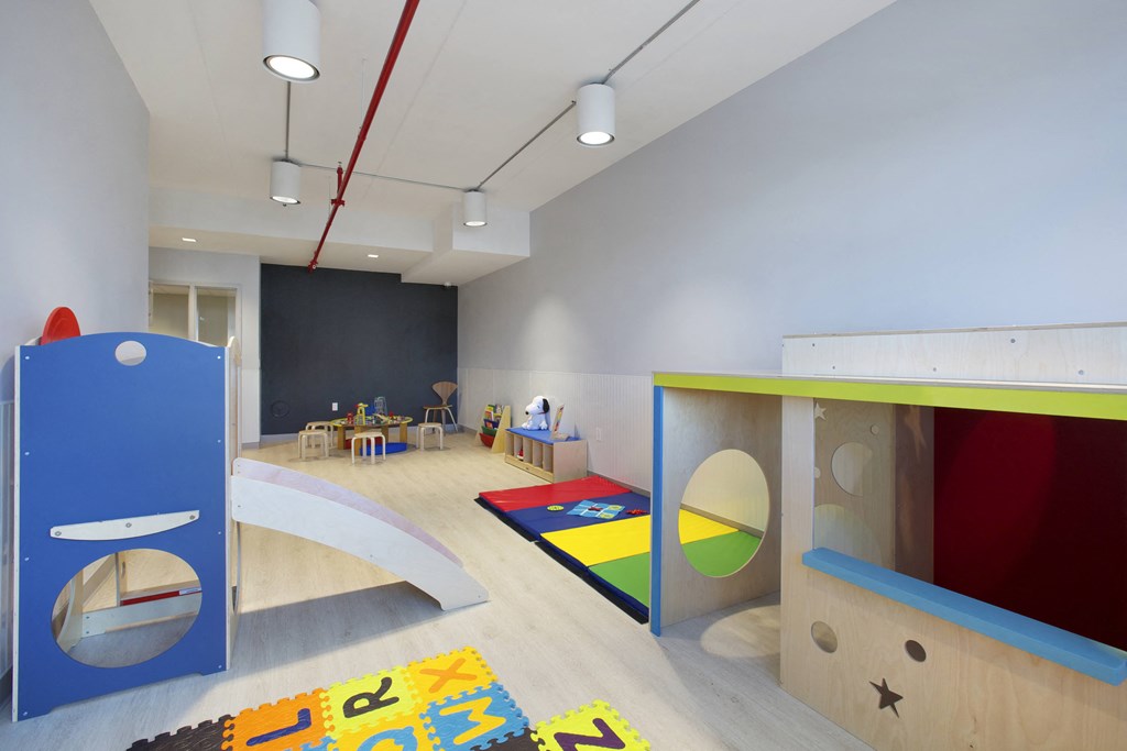 a childrens play room with a bunk bed and a play area with a desk