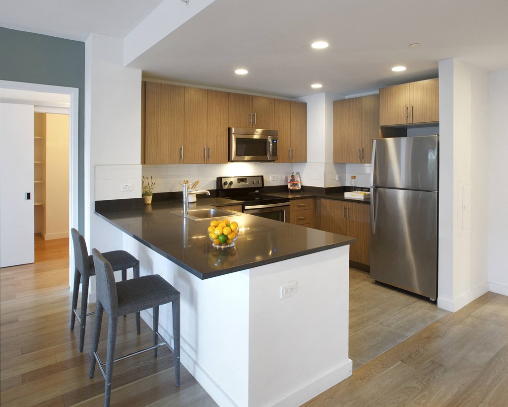 a kitchen with a large island and stainless steel appliances