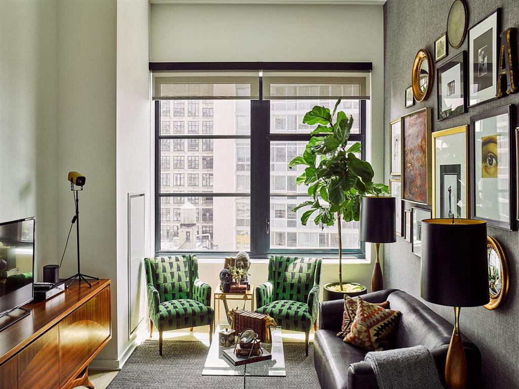A living room with a green chair and a brown leather couch.