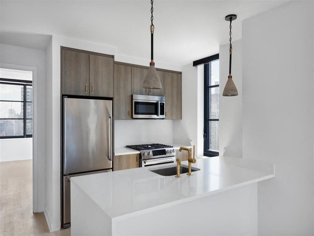 A modern kitchen with a stainless steel refrigerator and a white countertop.
