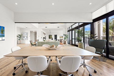 A modern dining room with a large table and chairs.