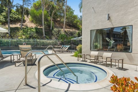 A hot tub with lounge chairs.