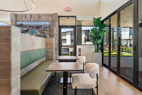 A room with a long table and chairs with a view of a pool outside.