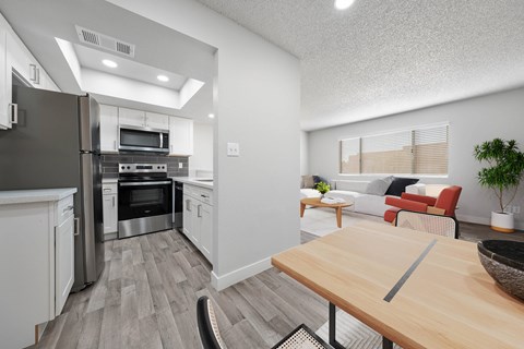 A modern kitchen with a wooden table and a refrigerator.