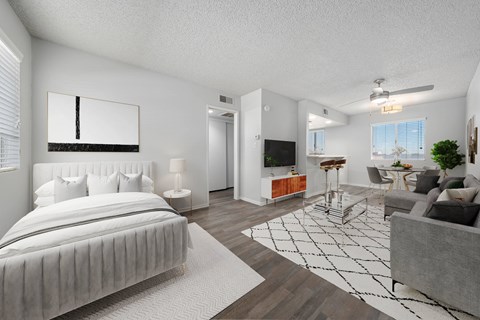 A modern bedroom with a large bed and a living area with a couch.