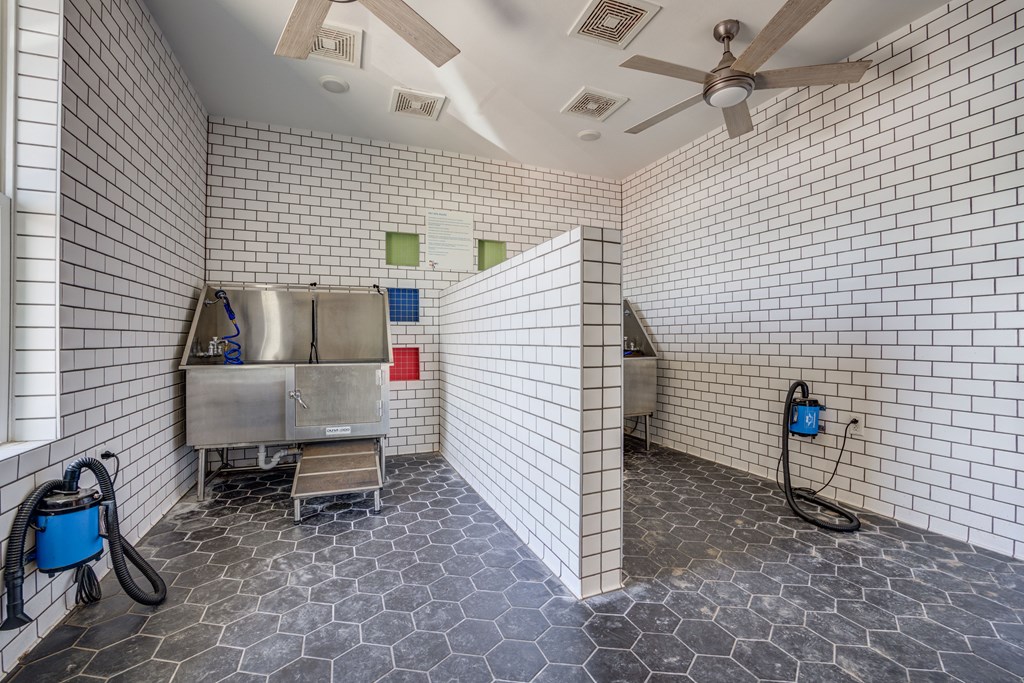 a white tiled bathroom with a stainless steel