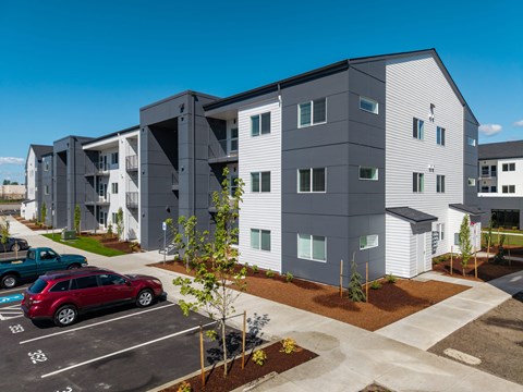 Modern apartment complex with a parking lot in front at The Arvon, Vancouver