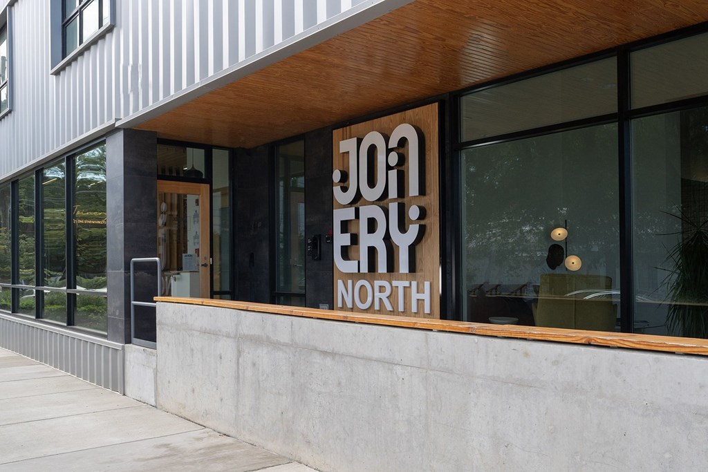 A modern building with a wooden facade and a glass door.