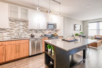 an open kitchen with a large island and stainless steel appliances