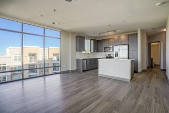 Living room and kitchen view with floor to ceiling windows for natural light - Photo Gallery 3