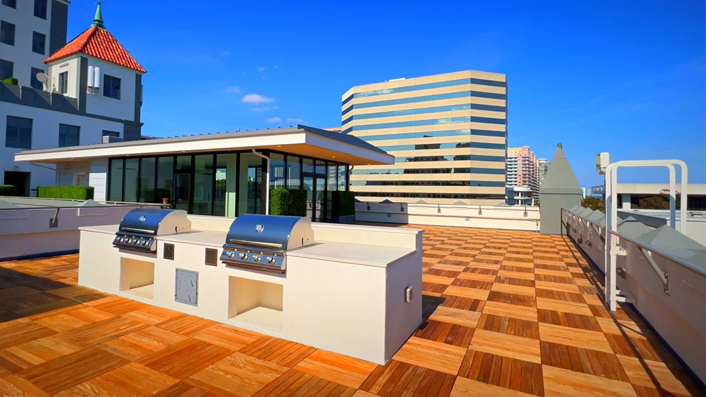 a rendering of a rooftop barbecue area with a city in the background