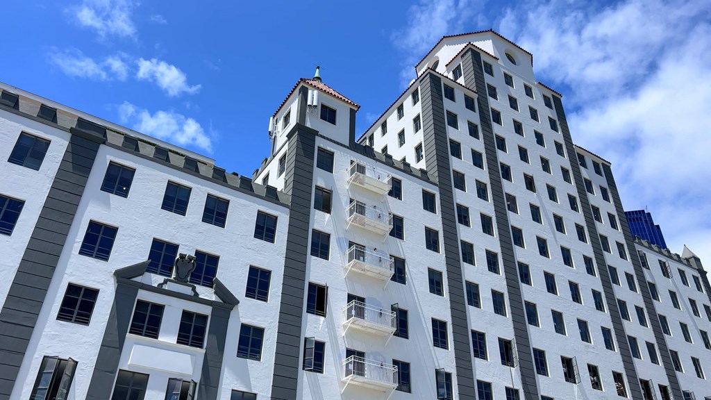 a white building with many windows and a blue sky