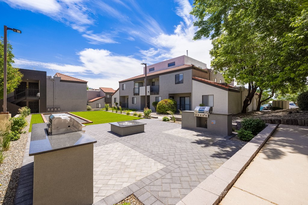 a courtyard with a building and a monument in front of it