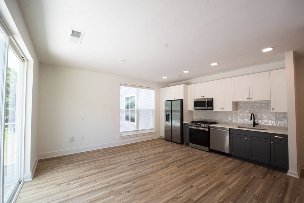 an empty kitchen with black appliances and white cabinets