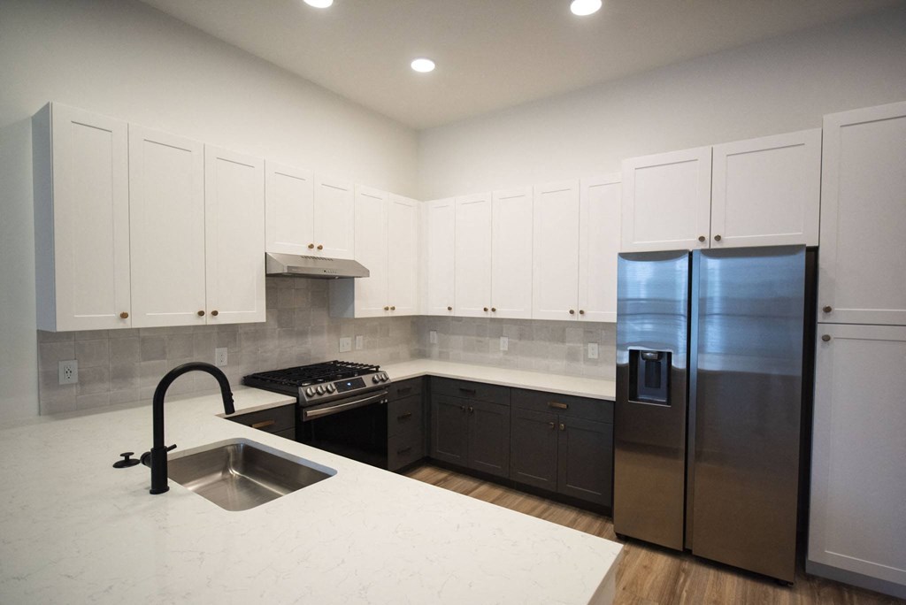 a kitchen with white cabinets and a stainless steel refrigerator