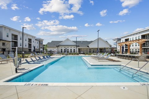 A large swimming pool with a building in the background.
