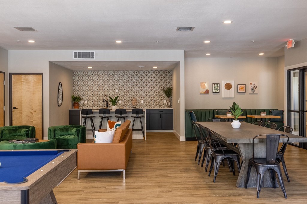 a clubhouse with a pool table and chairs and a dining area