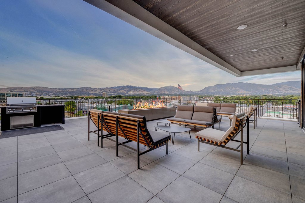 A patio with a table and chairs overlooking a mountain range.