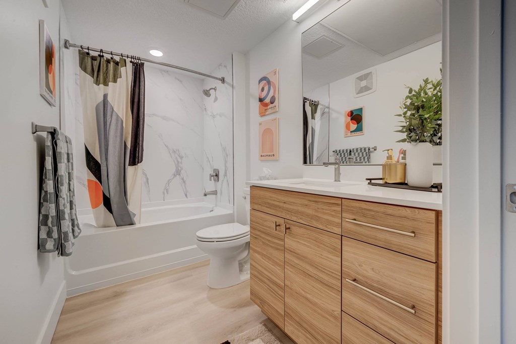 A bathroom with a toilet, sink, and a mirror.