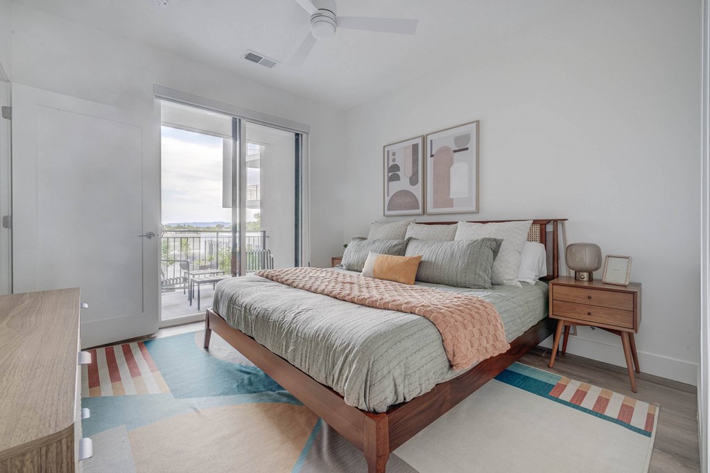 A bedroom with a bed, nightstand, and a ceiling fan.