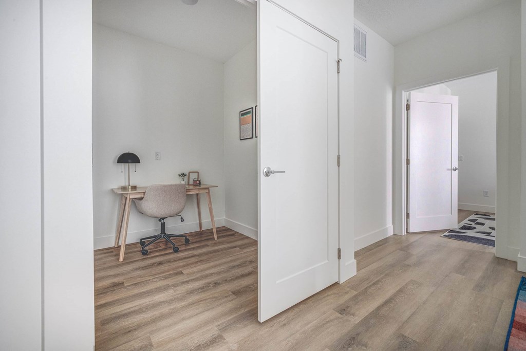 A room with a desk and chair in it.