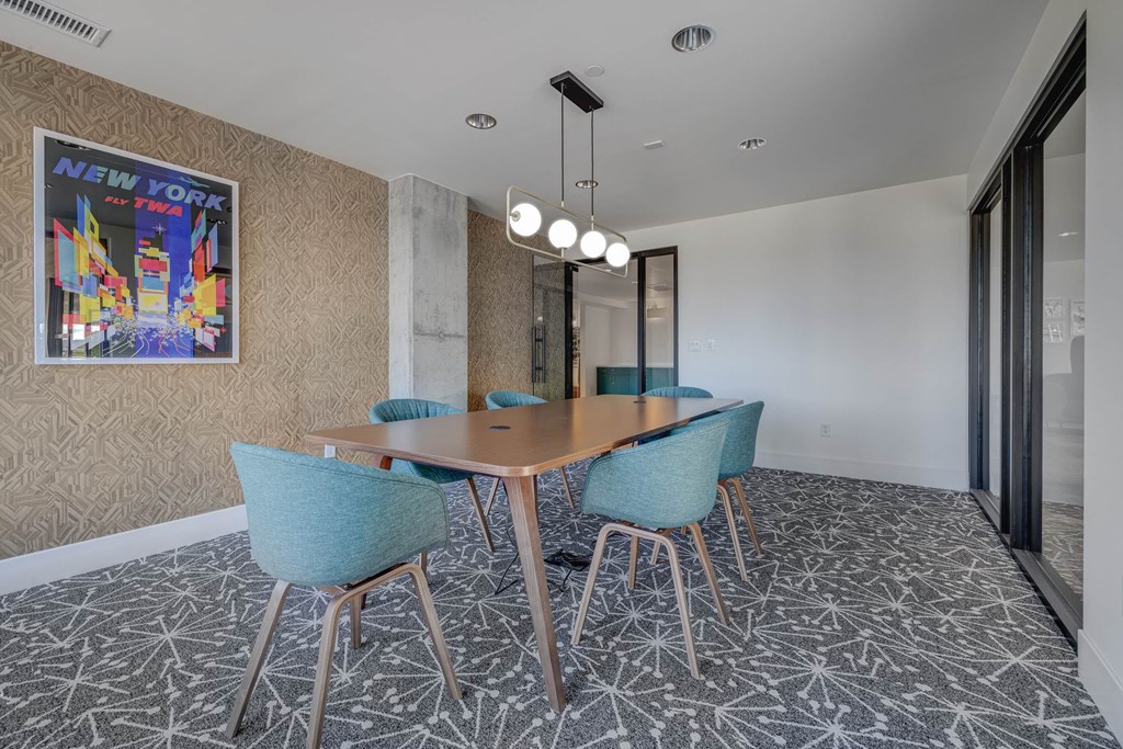A conference room with a wooden table and blue chairs.