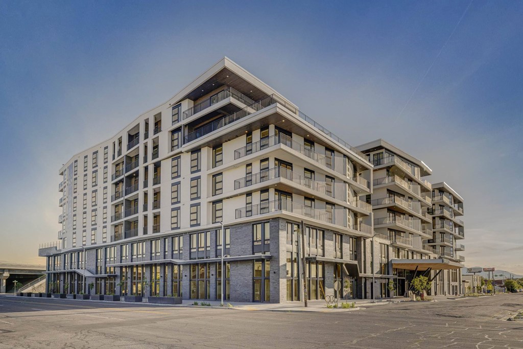 A large, modern building with a flat roof and multiple balconies.