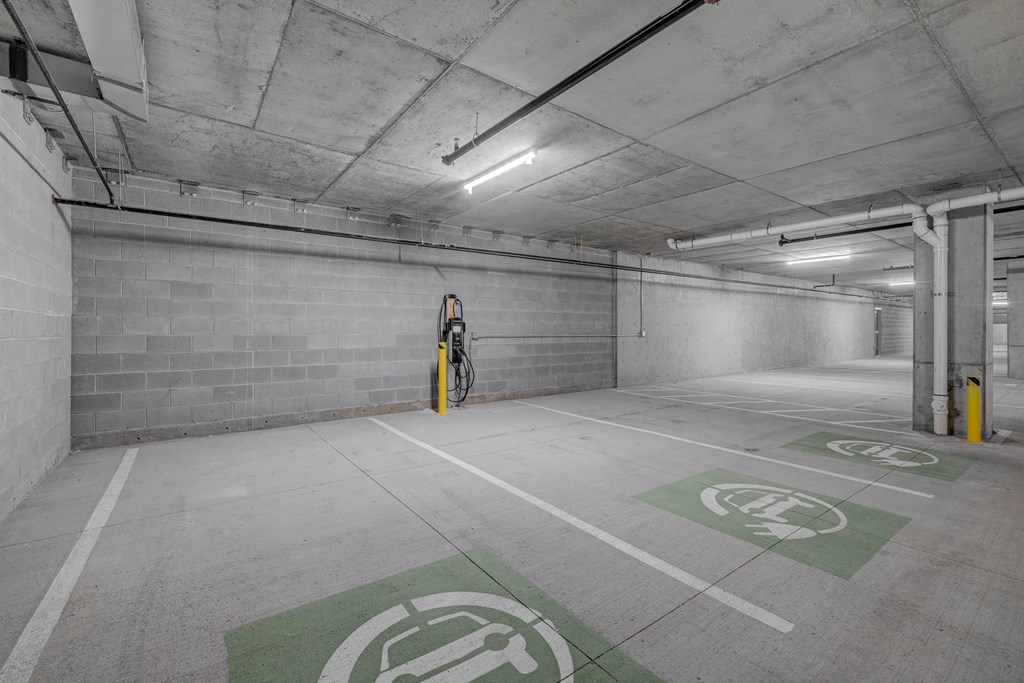 A parking garage with a bicycle parked in the corner.
