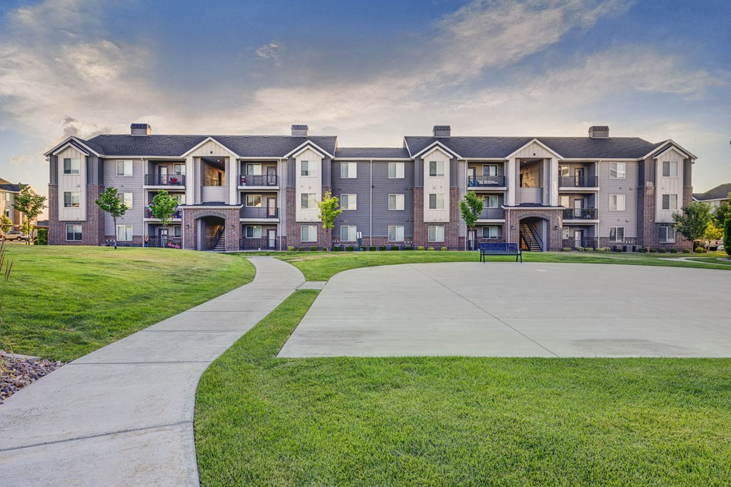 a sidewalk in front of an apartment building with a playground