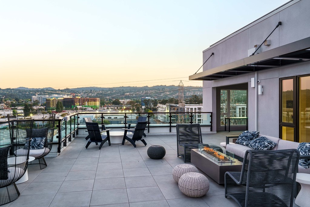 a terrace with a table and chairs and a view of the city