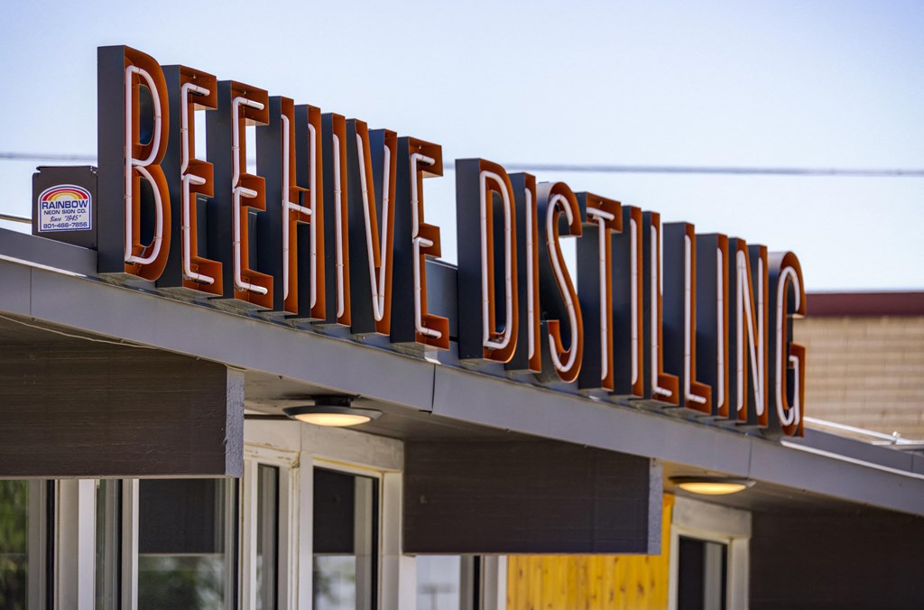 A sign for BeeHive Distilling is displayed on a building.