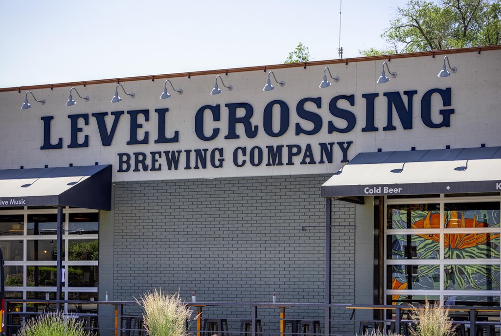 A beer company called Level Crossing has a building with a sign on it.