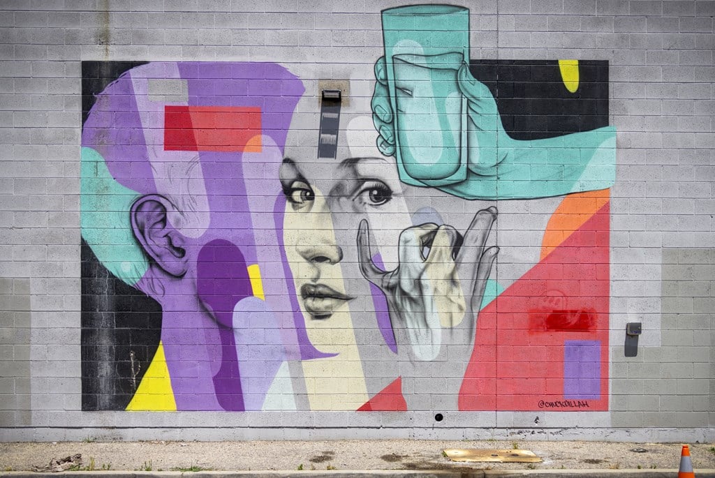 A colorful mural of a woman's face with a vase on her head.