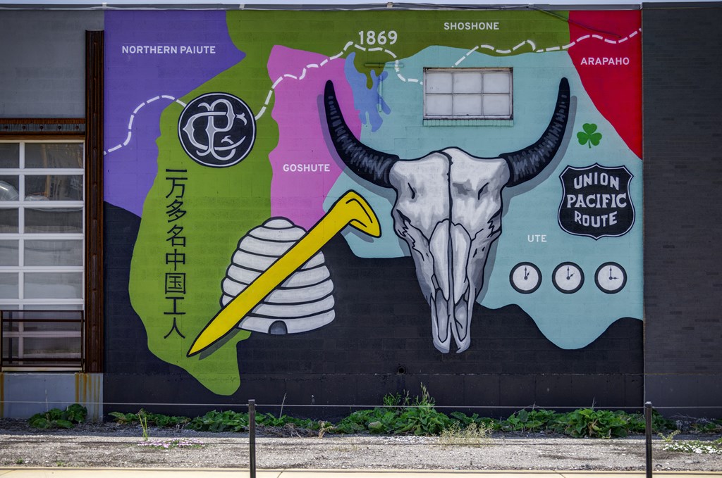 A mural on a wall with a skull and a pencil in the center.