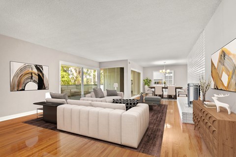 A modern living room with a white sofa and a wooden floor.