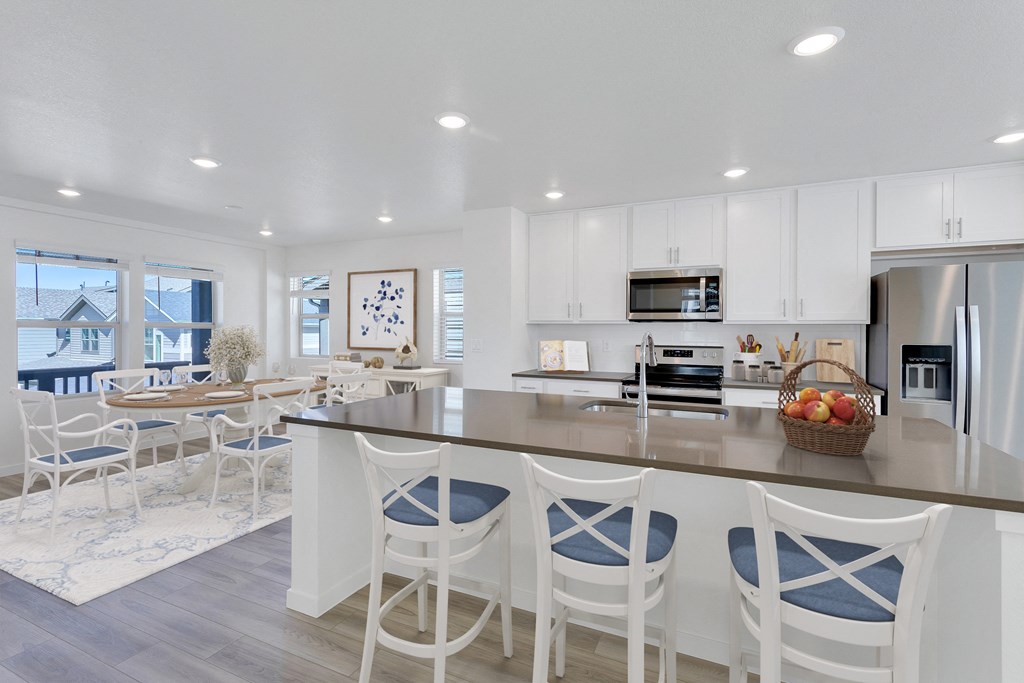 a large kitchen with a breakfast bar and a dining area