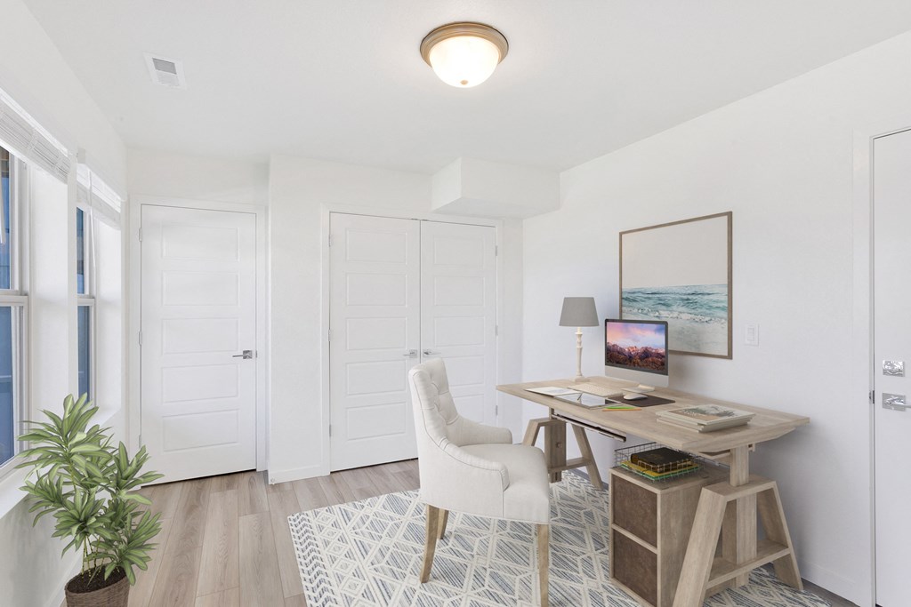 a home office with white walls and white doors and a desk with a white chair