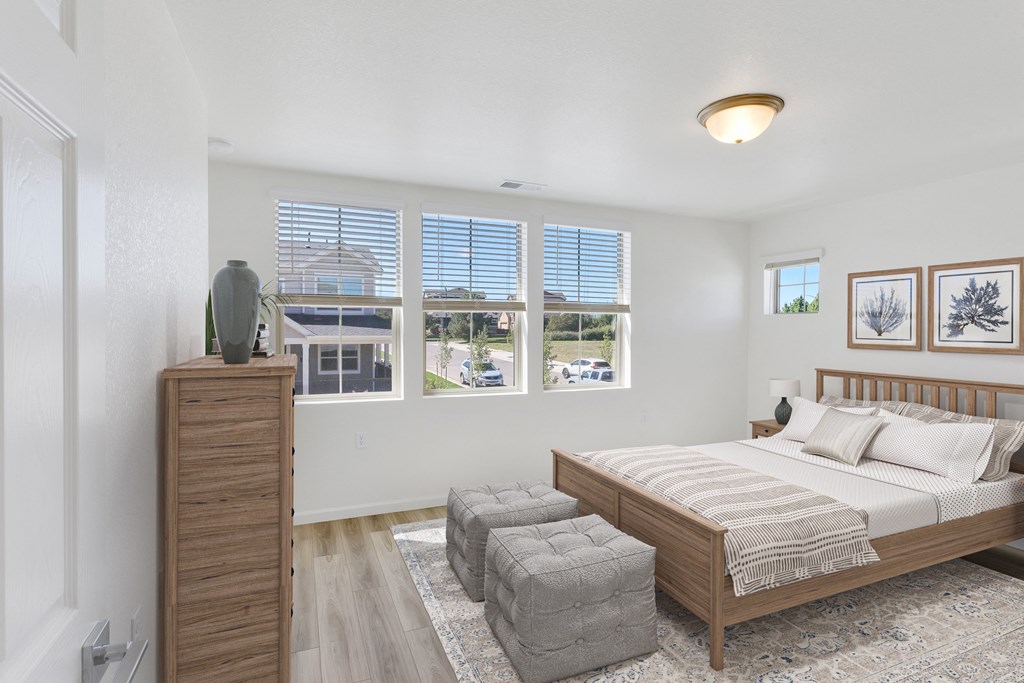 a bedroom with a bed and three windows