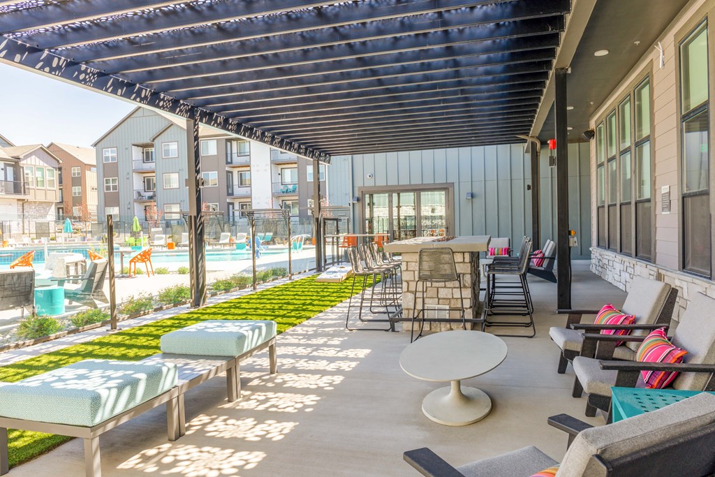 a patio with tables and chairs and a pool in a building