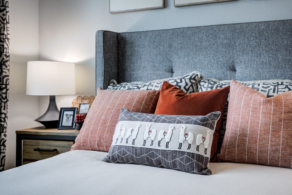 a bedroom with a bed with pillows and a nightstand with lamps