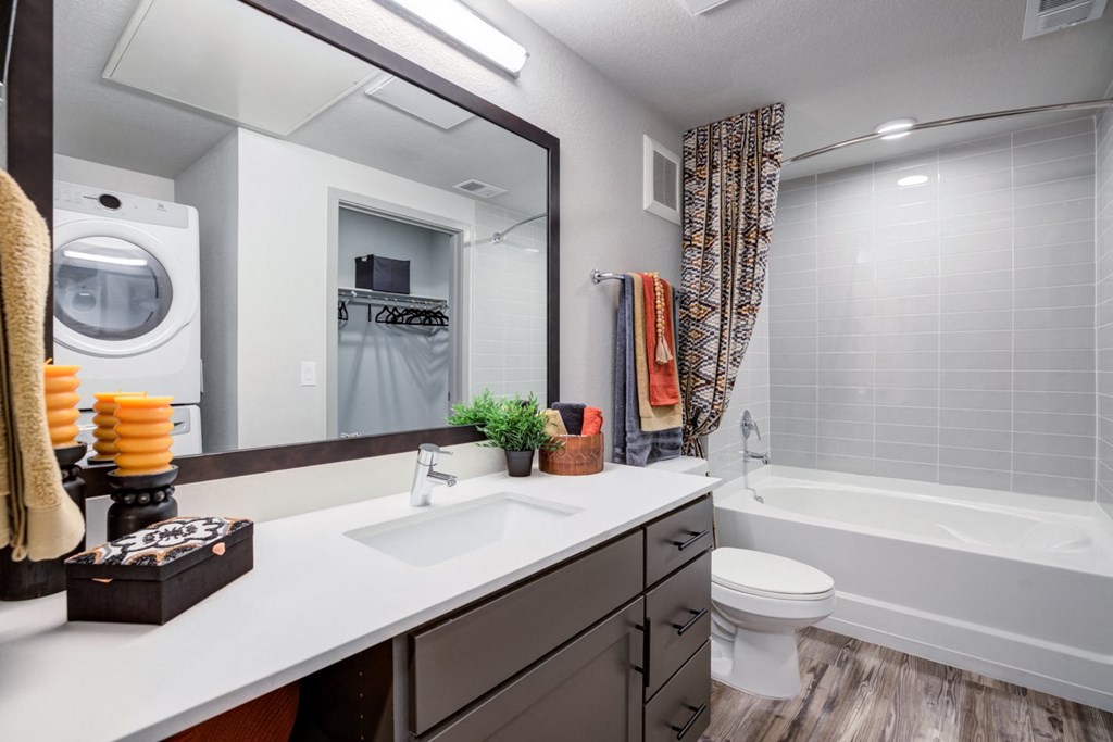 a bathroom with a sink toilet and tub and a washing machine