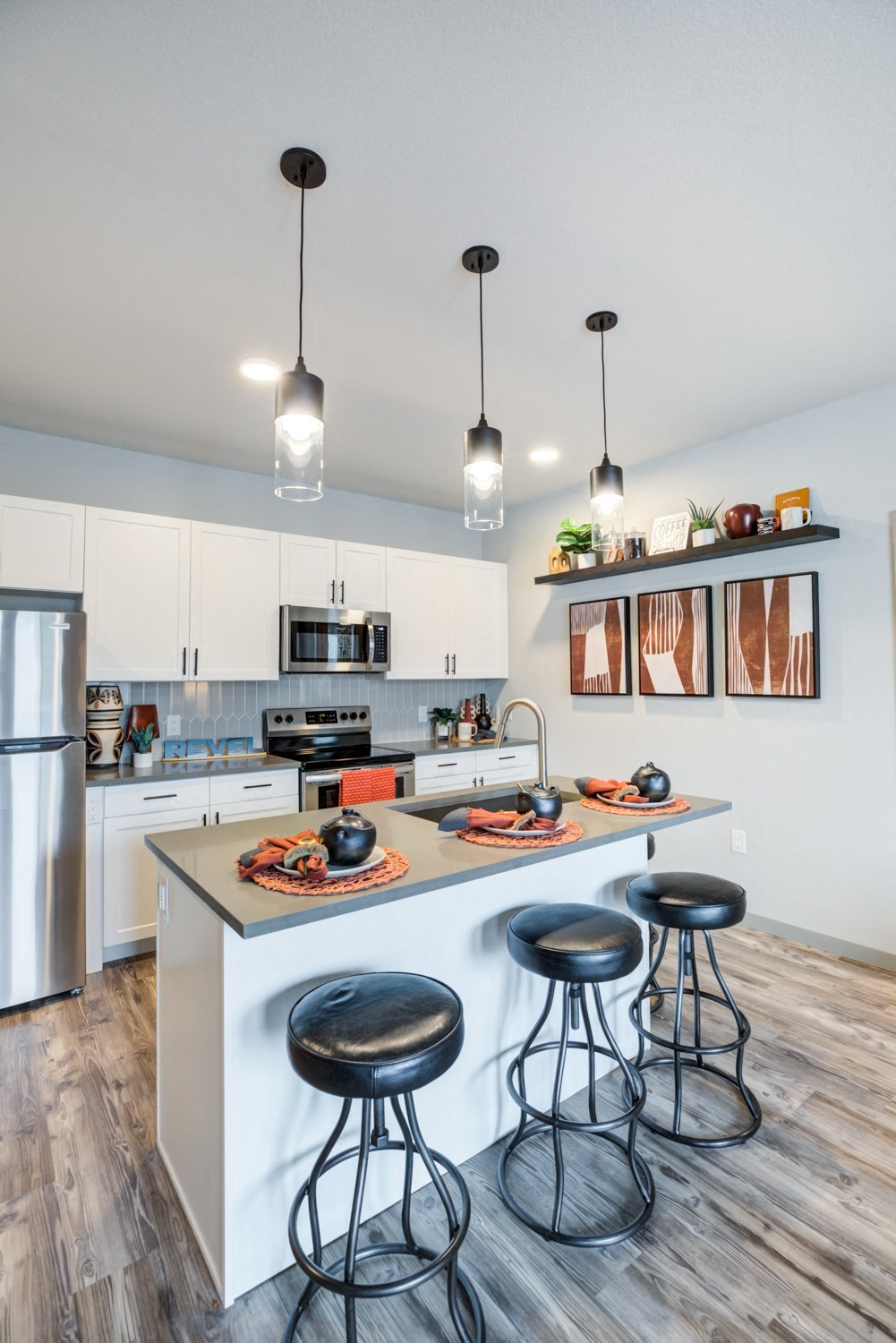 a kitchen with a large island with three stools