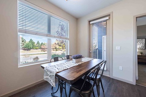 A dining room with a table and chairs.