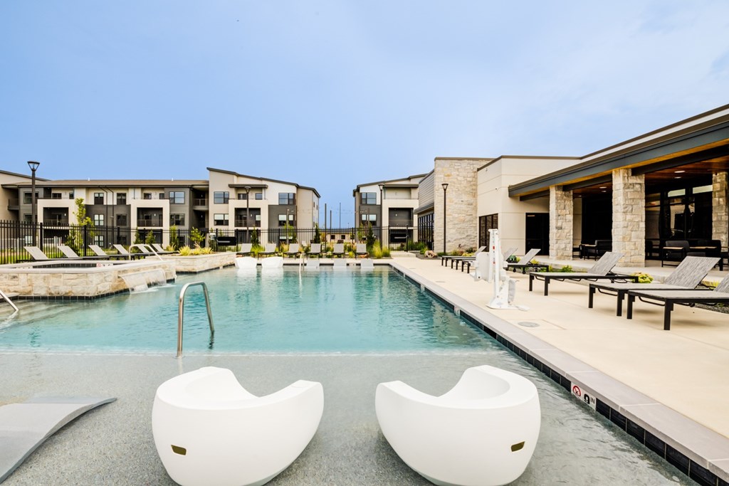 Two white chairs are placed in the middle of a pool.