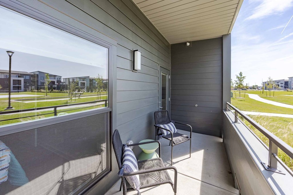 A balcony with a chair and a table with a striped towel on it.
