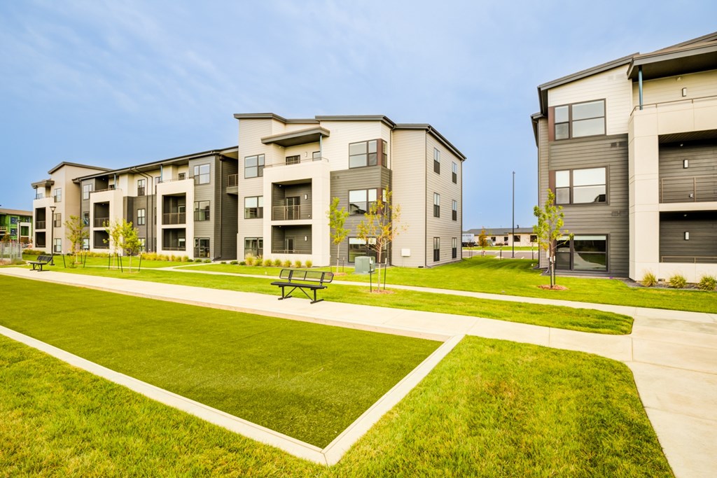 Apartment complex with a green lawn in front.