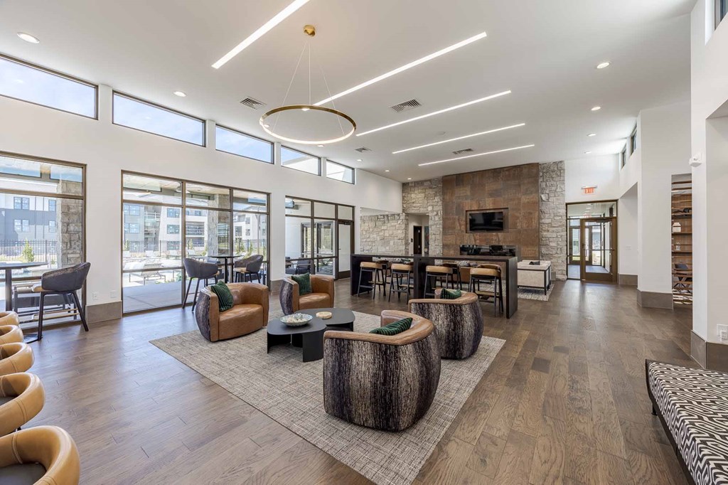 A spacious living room with a stone fireplace and wooden furniture.